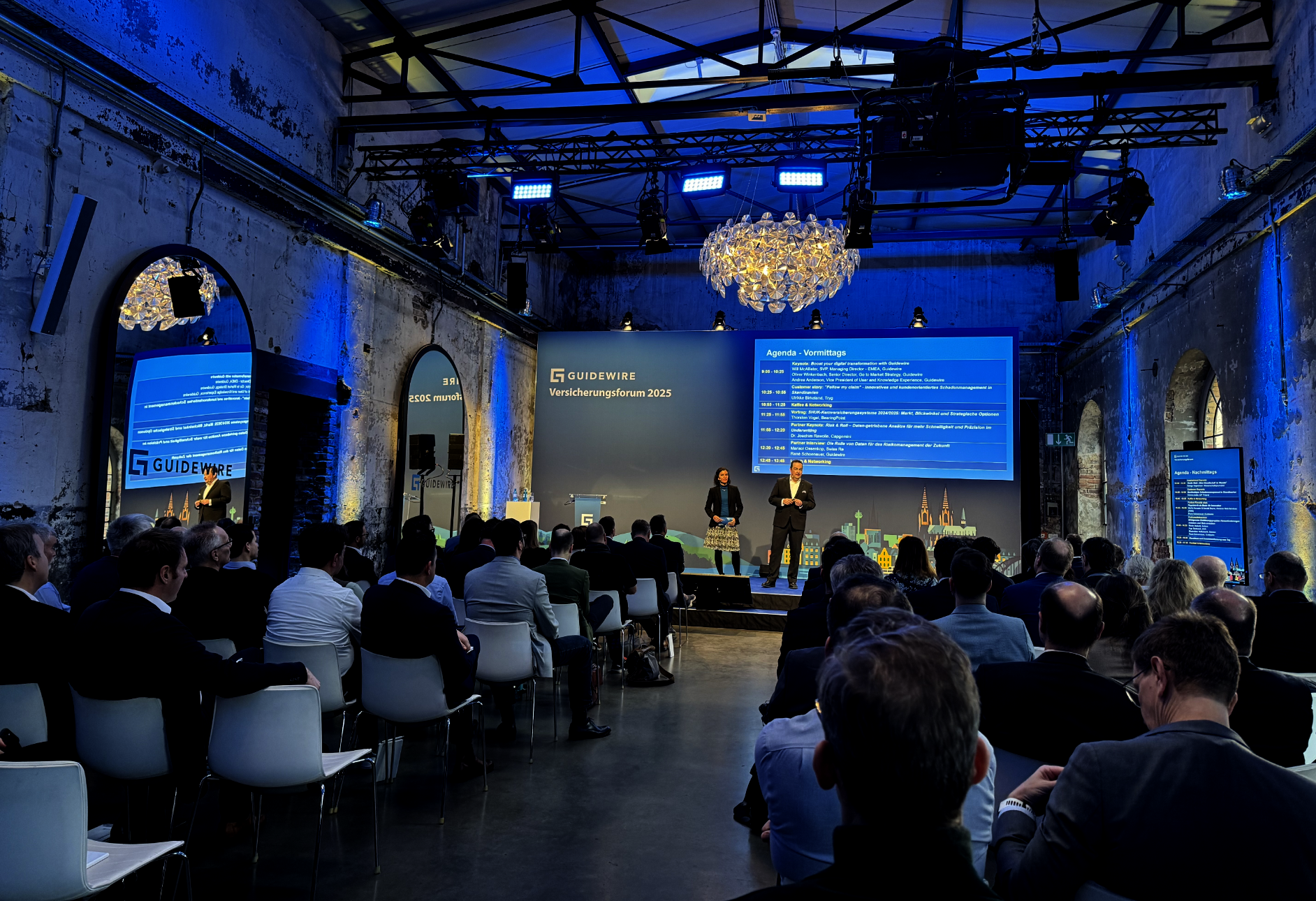 Regional Insurance Forum conference room with audience and screens